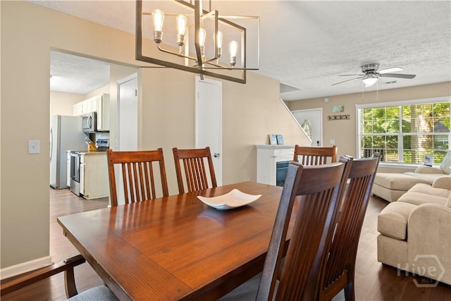 310 Mapmaker Ln, Savannah, GA 31410 - dining space featuring a textured ceiling, wood finished floors, ceiling fan, and a chandelier