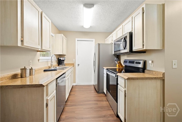 310 Mapmaker Ln, Savannah, GA 31410 - kitchen featuring stainless steel appliances, light wood finished floors, a textured ceiling, and light countertops
