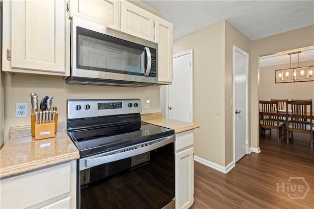 310 Mapmaker Ln, Savannah, GA 31410 - kitchen featuring electric range, stainless steel microwave, dark wood-style flooring, white cabinets, and light stone counters