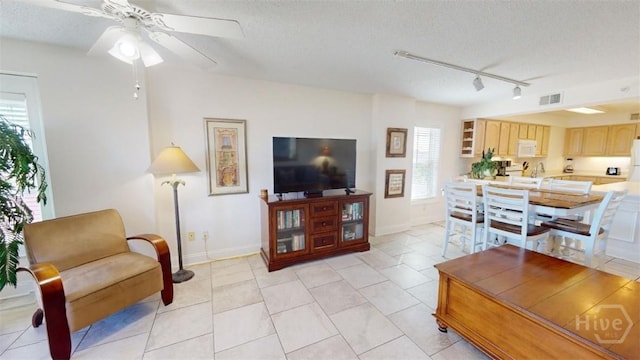 1609 Strand Ave Unit 306, Tybee Island, GA 31328 - living room featuring track lighting, a ceiling fan, a textured ceiling, and light tile patterned floors