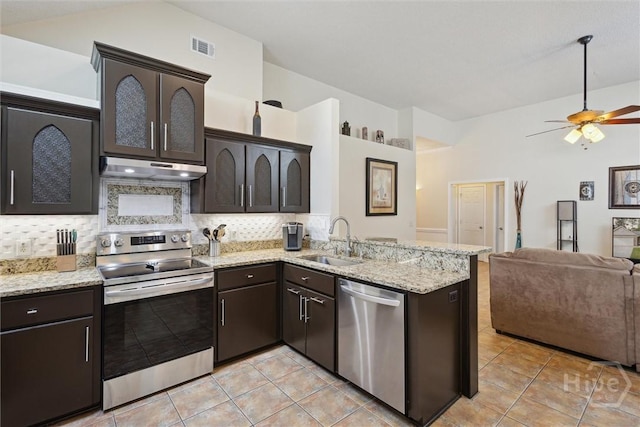 226 Silver Brook Cir, Pooler, GA 31322 - kitchen featuring appliances with stainless steel finishes, under cabinet range hood, open floor plan, tasteful backsplash, and dark brown cabinetry