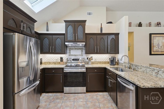 226 Silver Brook Cir, Pooler, GA 31322 - kitchen featuring appliances with stainless steel finishes, under cabinet range hood, a skylight, dark brown cabinetry, and decorative backsplash