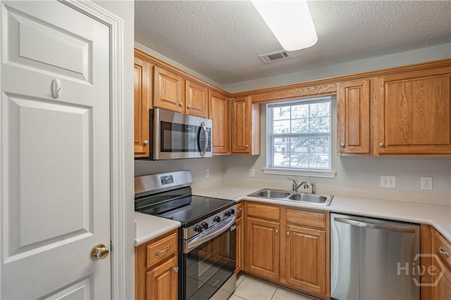 76 Al Henderson Blvd Unit G-4, Savannah, GA 31419 - kitchen with appliances with stainless steel finishes, a textured ceiling, light tile patterned flooring, brown cabinets, and light countertops