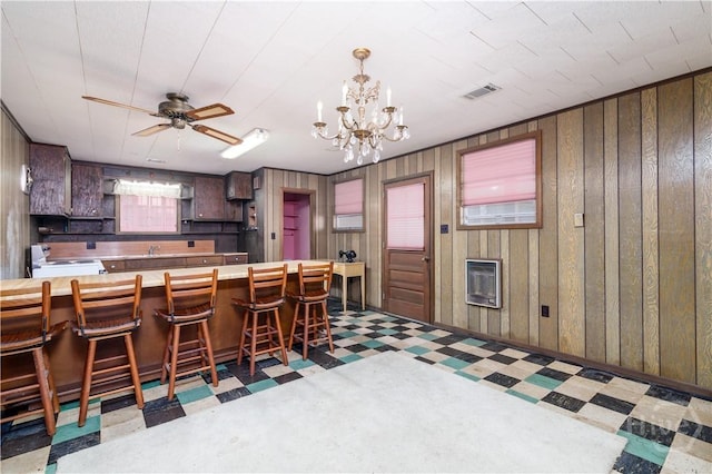 401 E Smith St, Claxton, GA 30417 - kitchen featuring tile patterned floors, white range with electric stovetop, heating unit, a chandelier, and wood walls