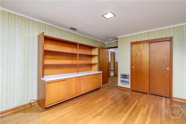 401 E Smith St, Claxton, GA 30417 - unfurnished bedroom with wallpapered walls, crown molding, light wood finished floors, a closet, and heating unit