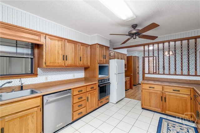 401 E Smith St, Claxton, GA 30417 - kitchen with dishwasher, oven, freestanding refrigerator, wallpapered walls, and ceiling fan