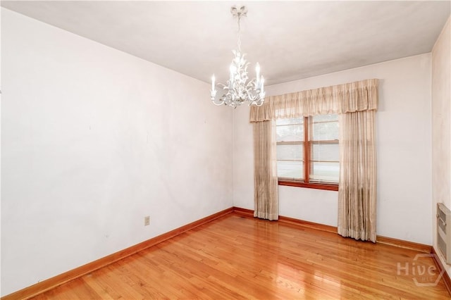 401 E Smith St, Claxton, GA 30417 - unfurnished room with a chandelier and light wood-style flooring