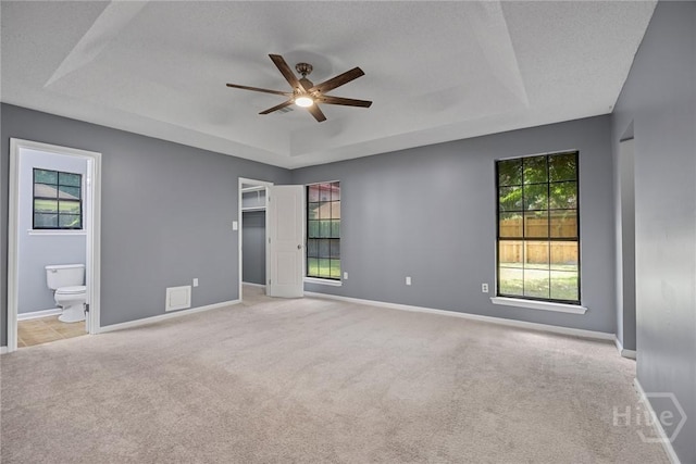 2 Brandle Cv, Savannah, GA 31405 - empty room featuring a raised ceiling, ceiling fan, plenty of natural light, and carpet flooring