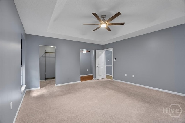 2 Brandle Cv, Savannah, GA 31405 - unfurnished bedroom featuring carpet, a tray ceiling, ceiling fan, and a walk in closet