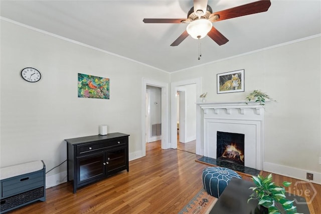 1405 E 51st St, Savannah, GA 31404 - living room featuring wood finished floors, ceiling fan, a warm lit fireplace, and ornamental molding