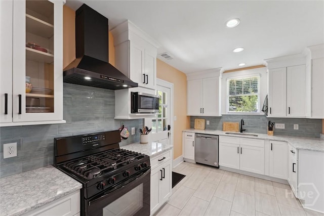 1405 E 51st St, Savannah, GA 31404 - kitchen with wall chimney exhaust hood, stainless steel appliances, tasteful backsplash, white cabinets, and recessed lighting