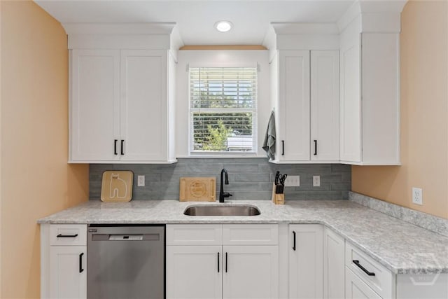 1405 E 51st St, Savannah, GA 31404 - kitchen featuring stainless steel dishwasher, decorative backsplash, white cabinets, and light stone countertops