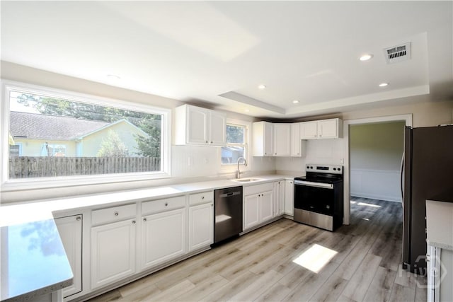 1003 Lora St, Savannah, GA 31410 - kitchen with appliances with stainless steel finishes, a raised ceiling, white cabinets, light wood-style floors, and recessed lighting
