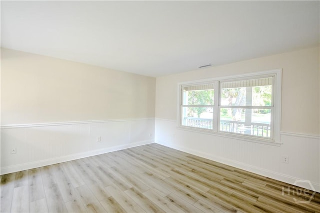 1003 Lora St, Savannah, GA 31410 - empty room with wood finished floors and a wainscoted wall