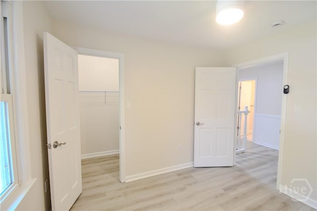 1003 Lora St, Savannah, GA 31410 - unfurnished bedroom featuring light wood-style flooring, a walk in closet, and a closet