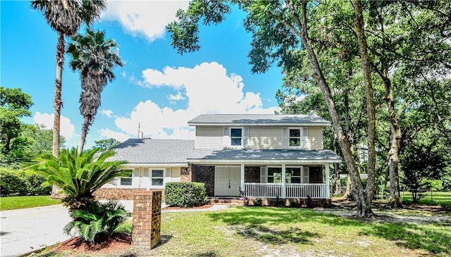 1003 Lora St, Savannah, GA 31410 - view of front facade with covered porch, a front yard, driveway, and brick siding