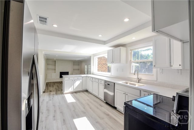 1003 Lora St, Savannah, GA 31410 - kitchen with appliances with stainless steel finishes, recessed lighting, a peninsula, light countertops, and white cabinets