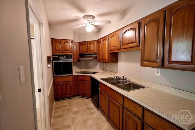 111 Oaklawn Dr, Rincon, GA 31326 - kitchen with black appliances, under cabinet range hood, ceiling fan, brown cabinetry, and light countertops