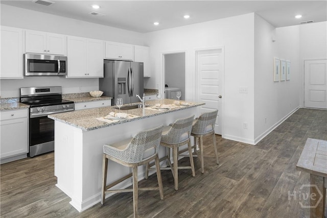 143 Crimson Ln, Savannah, GA 31302 - kitchen featuring appliances with stainless steel finishes, a kitchen island with sink, dark wood finished floors, recessed lighting, and white cabinets