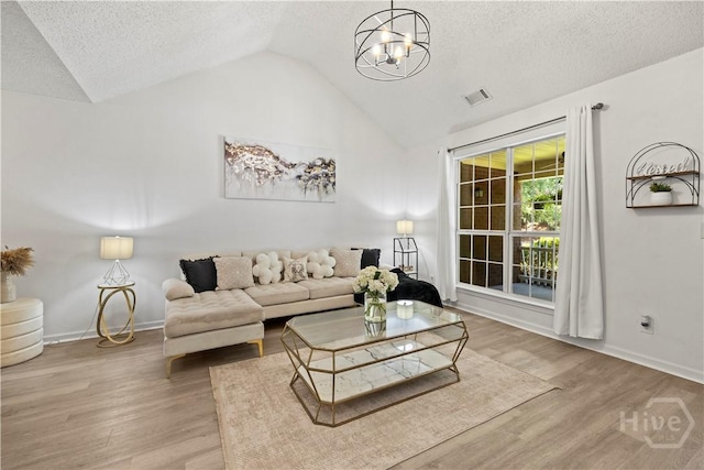 135 Trellis Way, Savannah, GA 31419 - living room featuring lofted ceiling, a textured ceiling, a chandelier, and wood finished floors