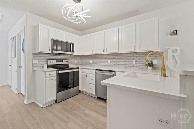 135 Trellis Way, Savannah, GA 31419 - kitchen featuring stainless steel appliances, light wood-style floors, a chandelier, decorative backsplash, and a textured ceiling