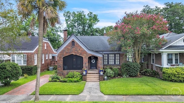 217 E 54th St, Savannah, GA 31405 - view of front of house featuring brick siding, a front lawn, and a chimney