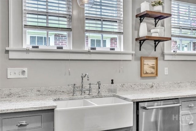 217 E 54th St, Savannah, GA 31405 - kitchen with stainless steel dishwasher, gray cabinets, open shelves, and light stone counters