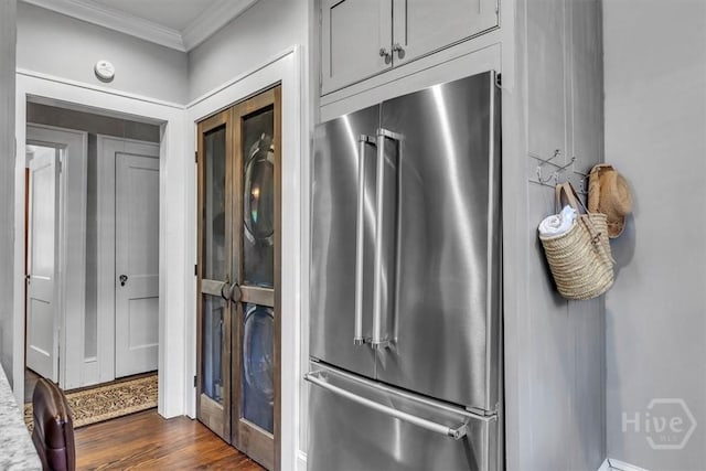217 E 54th St, Savannah, GA 31405 - washroom featuring crown molding, stacked washing machine and dryer, and dark wood-type flooring