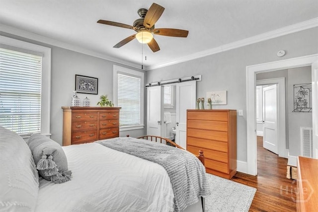 217 E 54th St, Savannah, GA 31405 - bedroom with wood finished floors, crown molding, a barn door, and ceiling fan