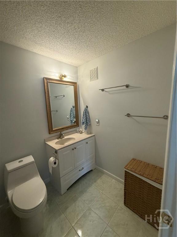 9307 Walden Park Dr, Savannah, GA 31410 - bathroom with a textured ceiling, vanity, and tile patterned flooring