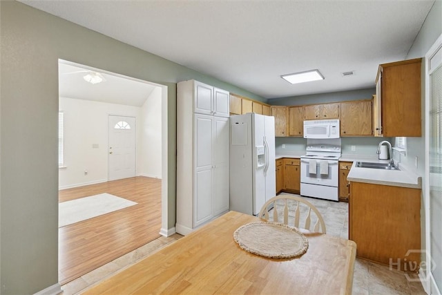 281 Barrister Cir, Guyton, GA 31312 - kitchen with white appliances, light countertops, light wood-type flooring, and brown cabinetry