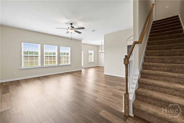 1161 Turpentine Trl, Hinesville, GA 31313 - unfurnished living room with a ceiling fan, stairs, dark wood-type flooring, and a chandelier