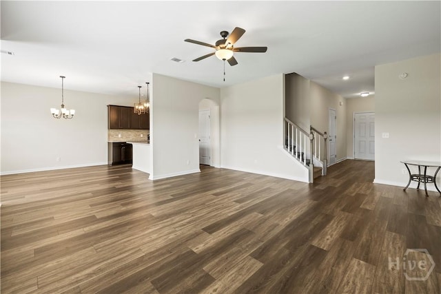 1161 Turpentine Trl, Hinesville, GA 31313 - unfurnished living room featuring a chandelier, stairway, a ceiling fan, dark wood-style floors, and arched walkways
