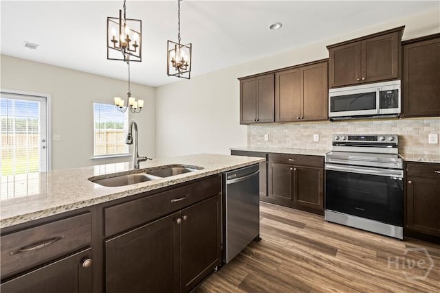 1161 Turpentine Trl, Hinesville, GA 31313 - kitchen featuring stainless steel appliances, a chandelier, dark brown cabinetry, and wood finished floors
