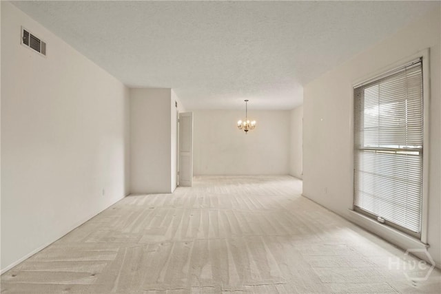 10804 Dorchester Rd, Savannah, GA 31406 - spare room featuring a chandelier, light carpet, and a textured ceiling