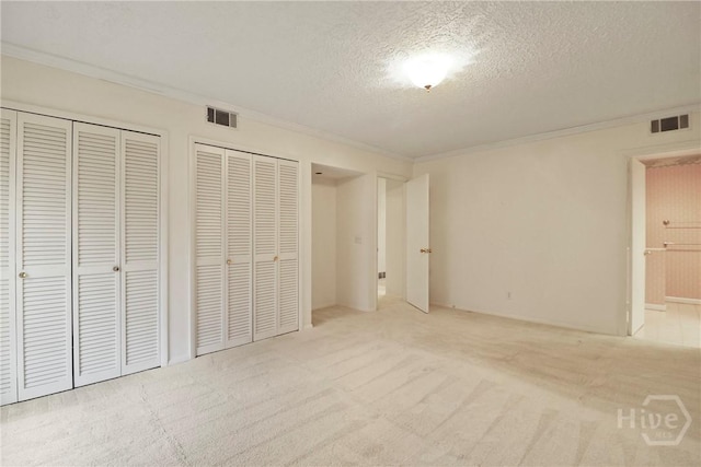 10804 Dorchester Rd, Savannah, GA 31406 - unfurnished bedroom with two closets, crown molding, a textured ceiling, and carpet flooring