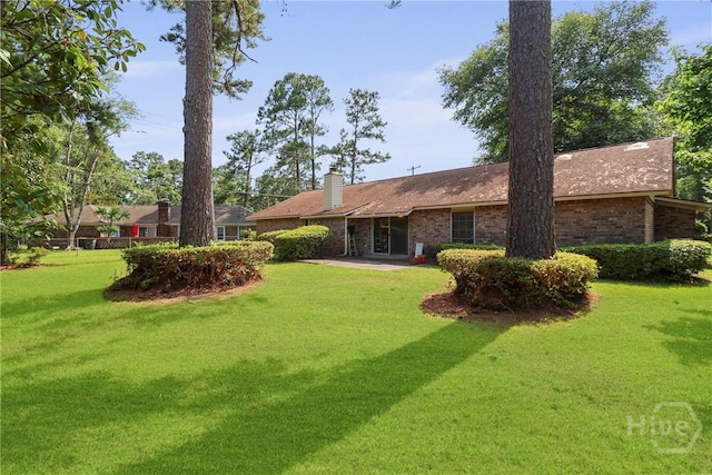 10804 Dorchester Rd, Savannah, GA 31406 - rear view of property featuring a lawn, brick siding, and a chimney
