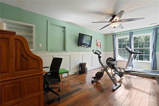 72 Roswell Trl, Richmond Hill, GA 31324 - exercise area featuring a wainscoted wall, a textured ceiling, ceiling fan, wood finished floors, and a decorative wall