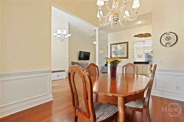 72 Roswell Trl, Richmond Hill, GA 31324 - dining room with a chandelier, a wainscoted wall, and light wood finished floors