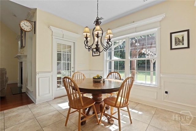72 Roswell Trl, Richmond Hill, GA 31324 - dining space with light tile patterned floors, a chandelier, a decorative wall, and a wainscoted wall