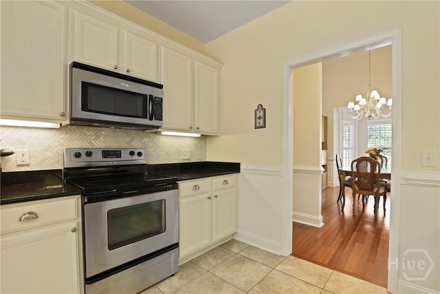 72 Roswell Trl, Richmond Hill, GA 31324 - kitchen with appliances with stainless steel finishes, a chandelier, light tile patterned floors, dark countertops, and tasteful backsplash