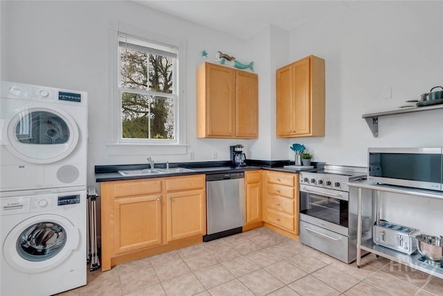 531 E Broad St, Savannah, GA 31401 - kitchen featuring appliances with stainless steel finishes, estacked washer and dryer, dark countertops, light tile patterned flooring, and light brown cabinetry