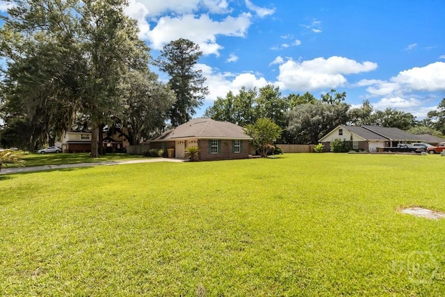 633 Greenwich Dr, Richmond Hill, GA 31324 - view of grassy yard with concrete driveway and an attached garage