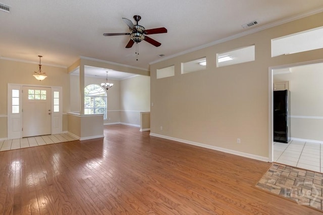 633 Greenwich Dr, Richmond Hill, GA 31324 - unfurnished living room featuring ceiling fan, light wood finished floors, ornamental molding, and a chandelier