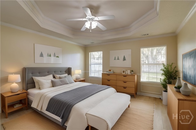 633 Greenwich Dr, Richmond Hill, GA 31324 - bedroom featuring a raised ceiling, multiple windows, crown molding, light wood-style floors, and a ceiling fan
