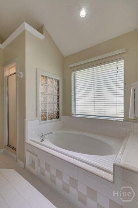 633 Greenwich Dr, Richmond Hill, GA 31324 - bathroom with tile patterned flooring, a garden tub, a shower stall, and lofted ceiling