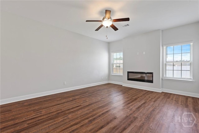 131 Guana Ln, Bloomingdale, GA 31302 - unfurnished living room featuring dark wood-type flooring, ceiling fan, and a glass covered fireplace