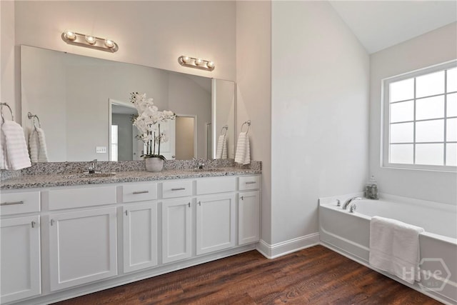 131 Guana Ln, Bloomingdale, GA 31302 - full bath featuring double vanity, wood finished floors, a garden tub, and vaulted ceiling