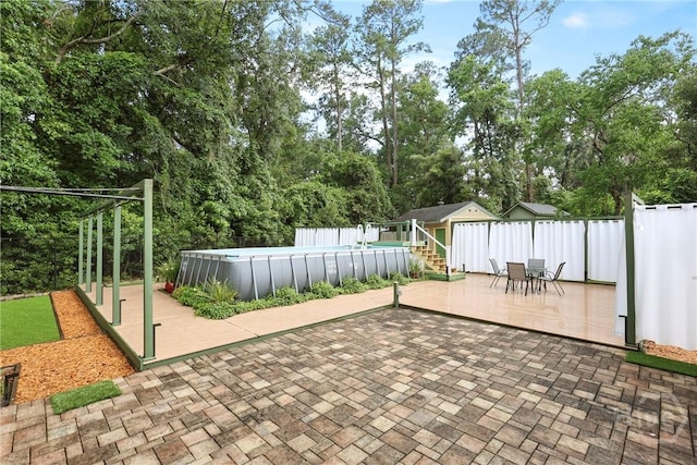 7619 Lynes Ct, Savannah, GA 31406 - fenced backyard with a deck, an outdoor pool, outdoor dining area, and view of wooded area