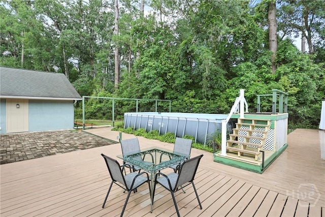 7619 Lynes Ct, Savannah, GA 31406 - wooden deck featuring an outdoor pool, view of wooded area, and outdoor dining area